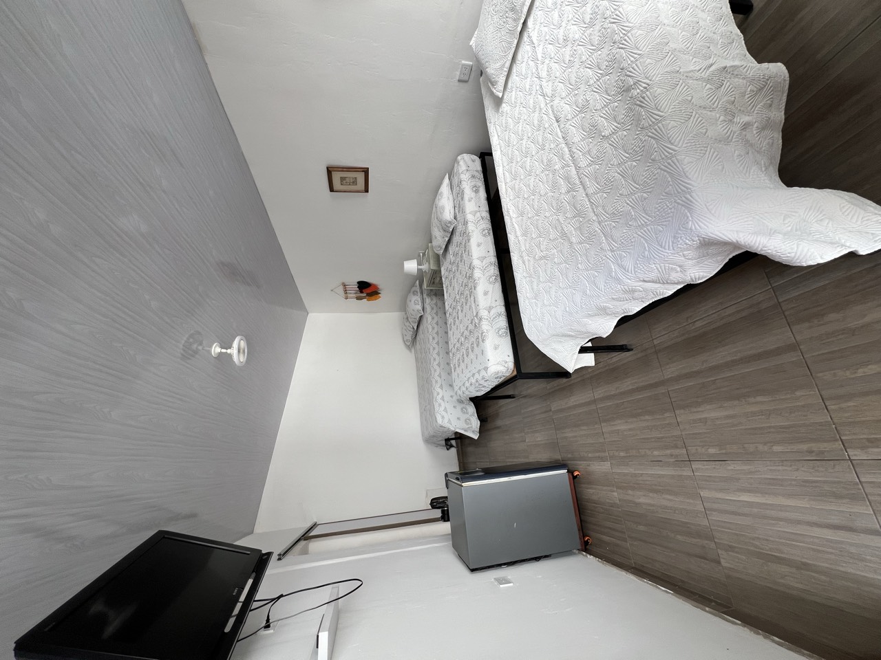 Camas y televisor de la habitación cuádruple en Roldanillo